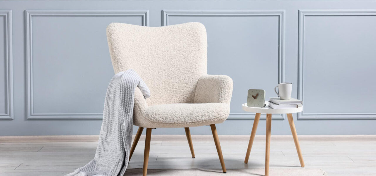 Chaise bouclette Meublissime associée à une ambiance cocooning avec une couverture, mettant en avant le confort et l’élégance dans un intérieur raffiné.